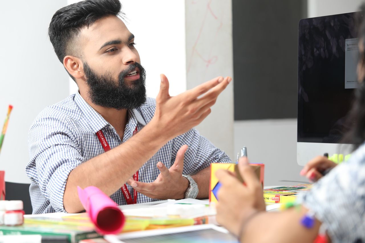 A young professional engaged in an office discussion, showcasing a collaborative workspace.